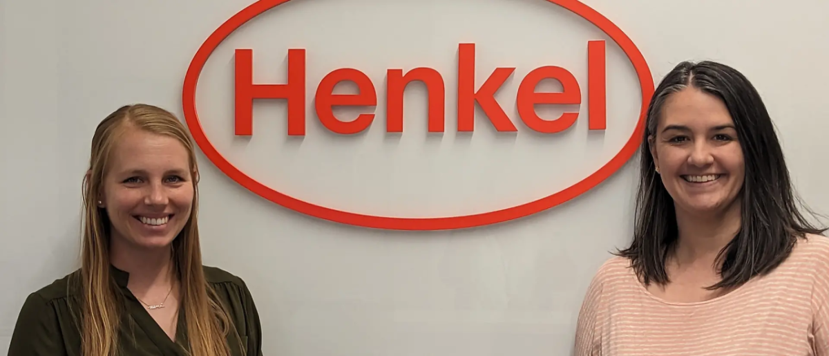 Elizabeth Arredondo and Diana Baker in front of Henkel logo