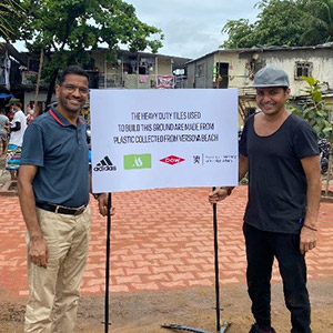 Milind and Afroz holding a sign