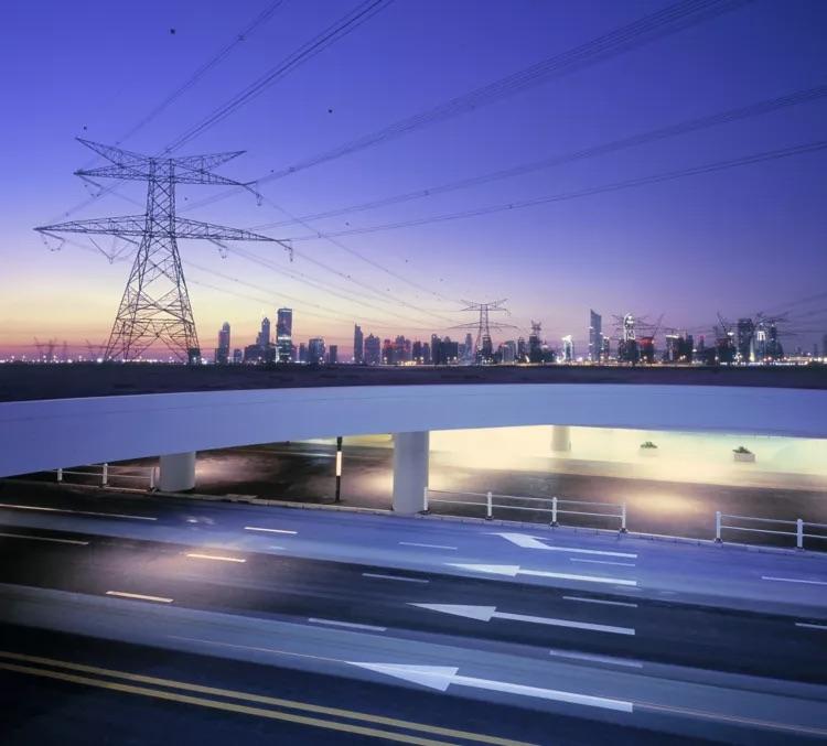 transmission tower with a city skyline in the background