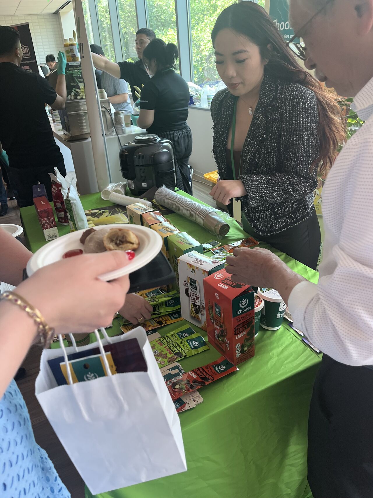 Various foods shown at a table, with three people standing next to it