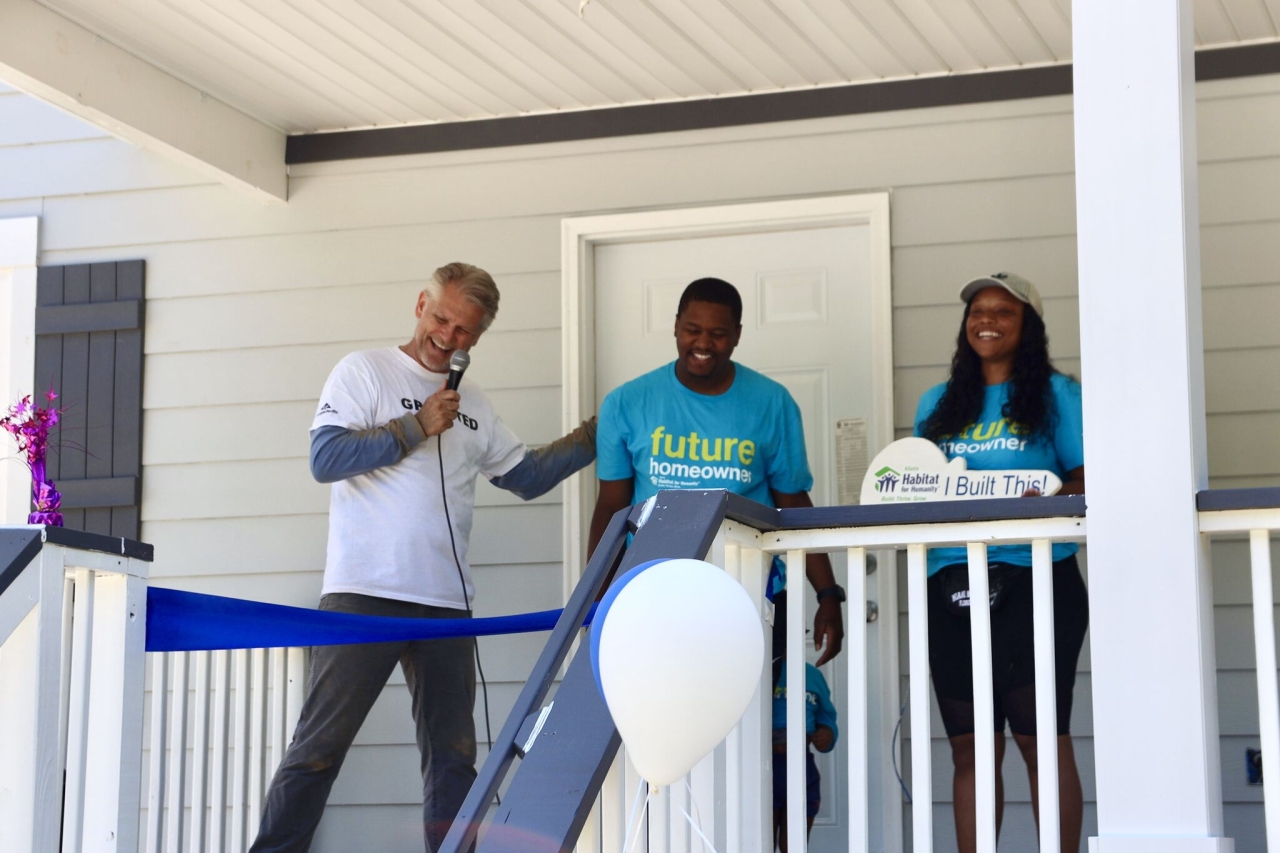 team standing in front of house