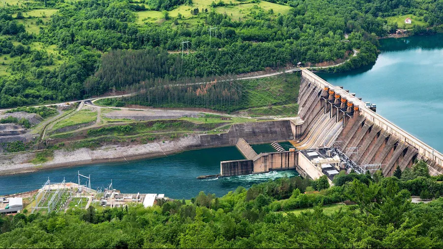 aerial view of a hydro electric dam and a forested riverway