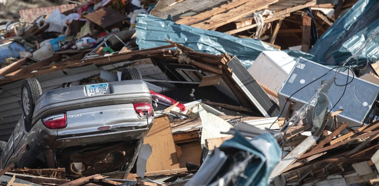 pile of wood, debris, and an overturned car