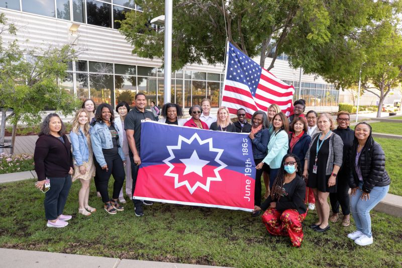 Employees posing with Juneteenth flag