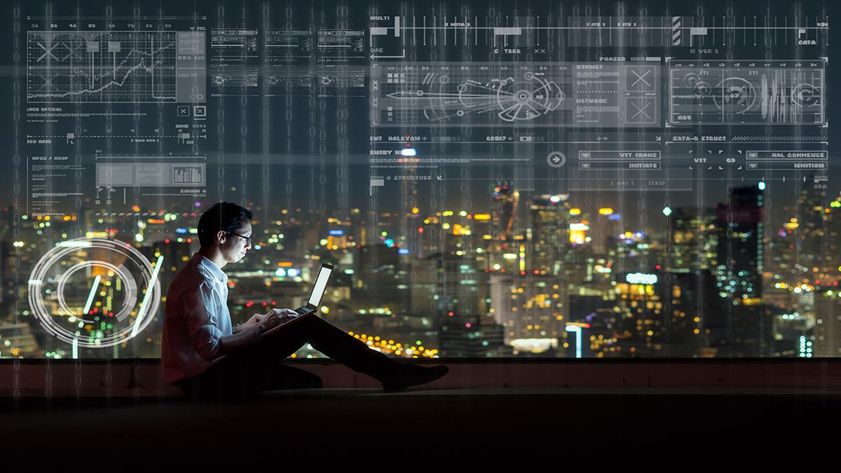 tech worker in front of a city skyline at night