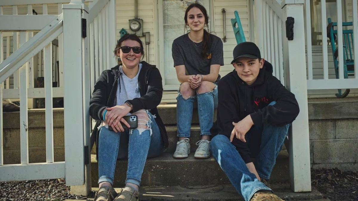 Three kids sit on steps