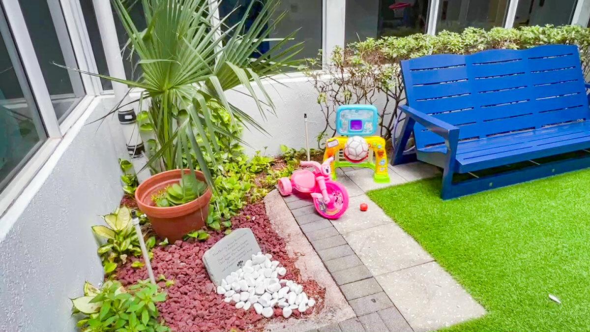 Kids toys and a blue chair in a grassy area