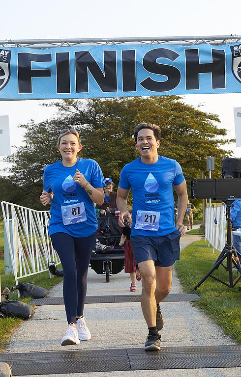 2 people run across the finish line