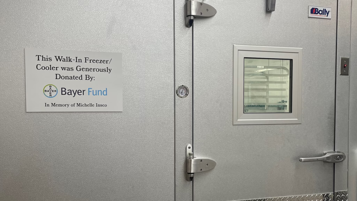 Walk in freezer with sign: This Walk-In Freezer/Cooler was generously donated by Bayer Fund
