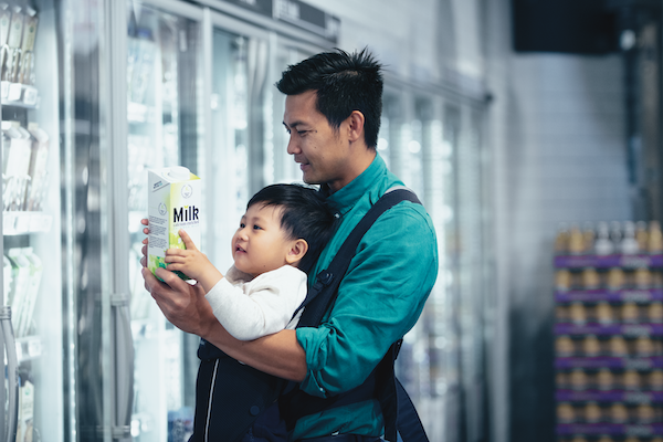 father and child with a carton of milk