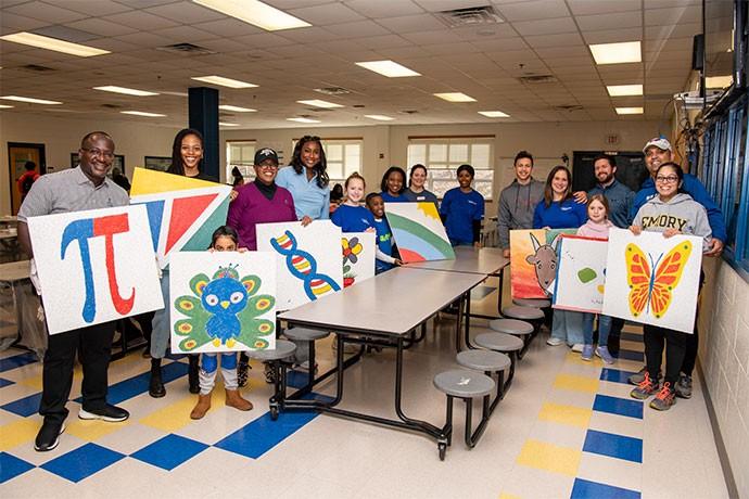group showing off their paintings 