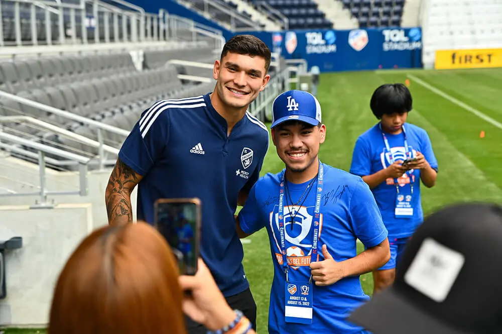 Student posing with an MLS player