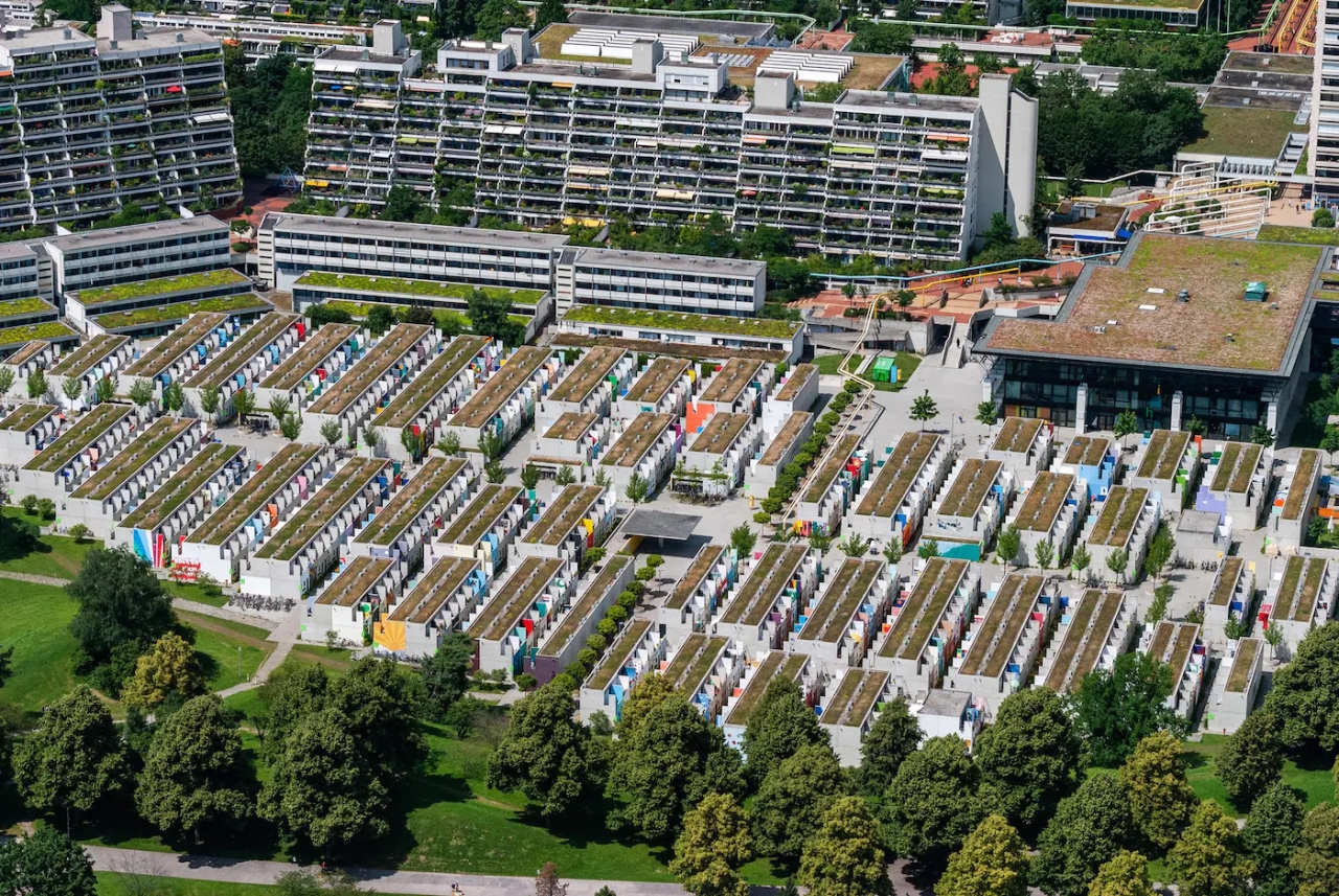 aerial view of huge housing complexes, tall and short apartment buildings, trees surround them