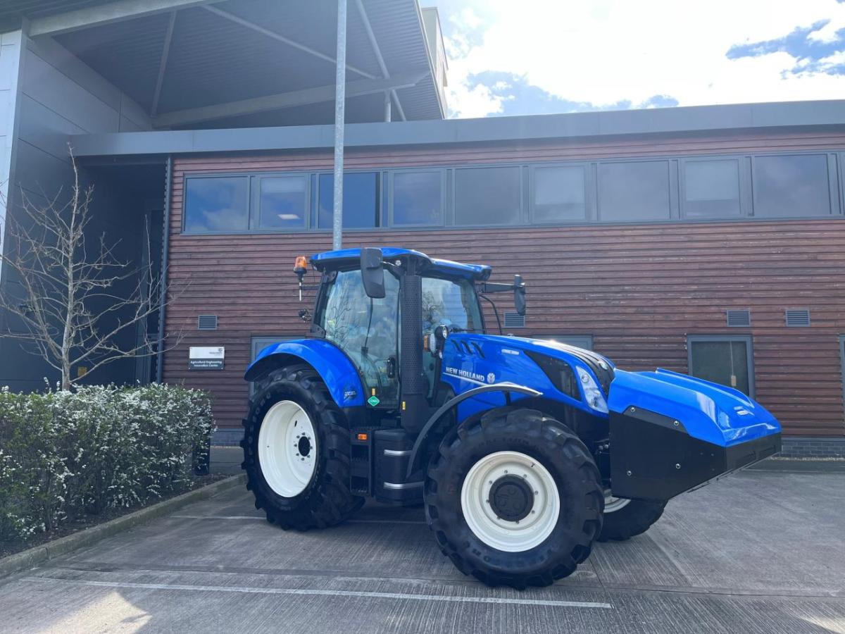 A blue New Holland tractor in a parking lot.
