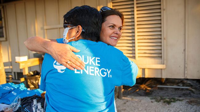 two people in duke energy t-shirts hugging