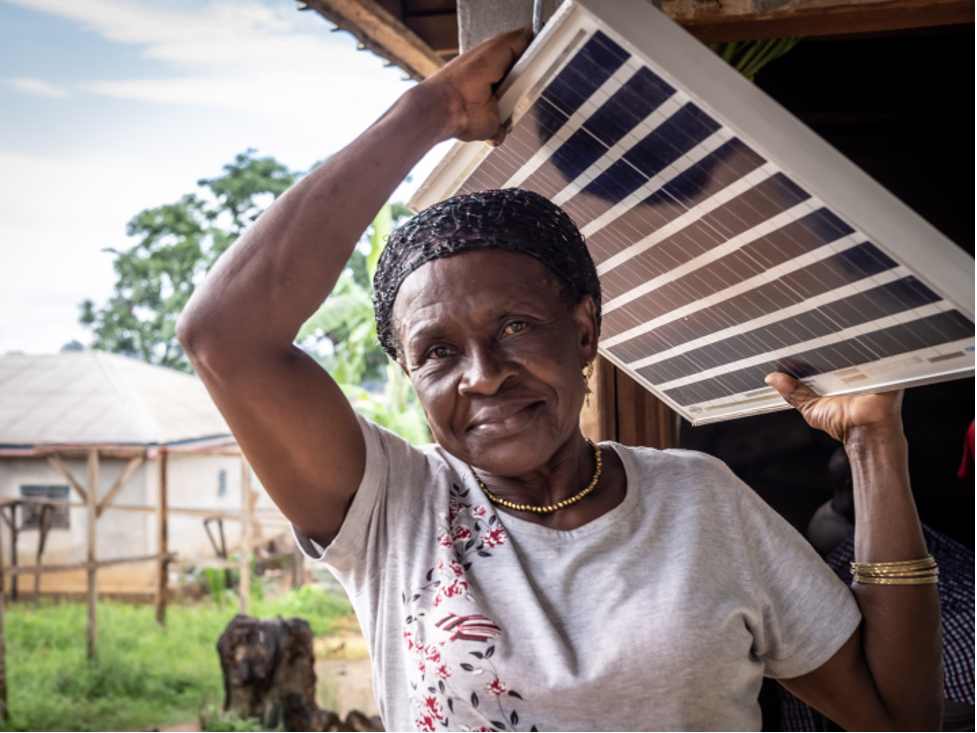 Woman carries a solar panel over her head