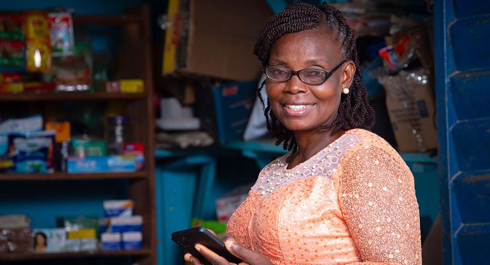 Person smiling while using smartphone at a business