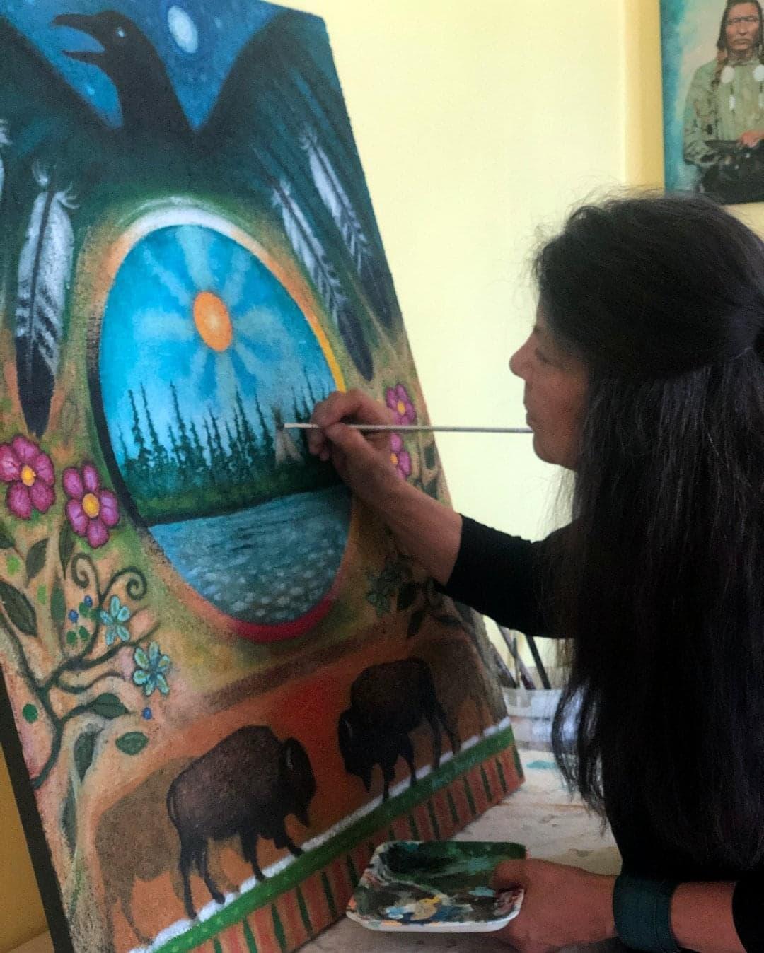 Artist Nancy Desjarlais working on a colorful painting
