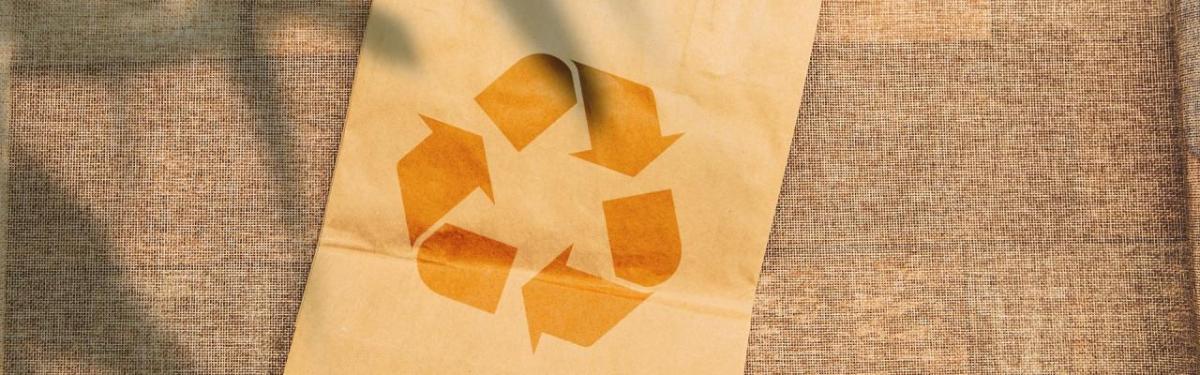 A brown paper bag with a recycling logo on it.