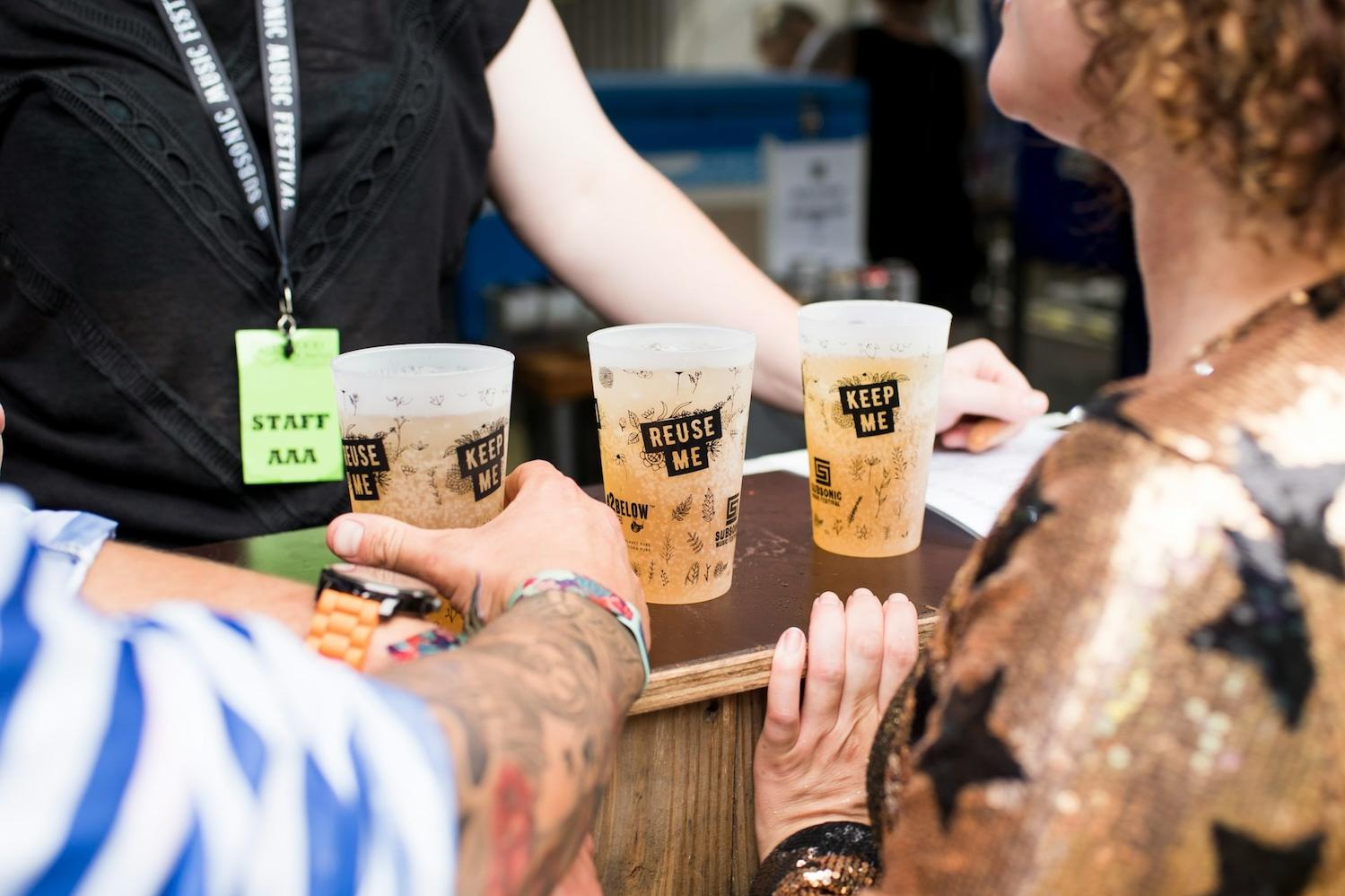 people get drinks in reusable cups at a music festival 