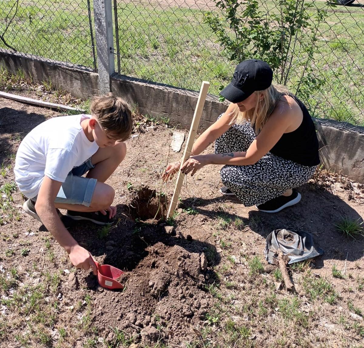 An adult and child digging a hole.