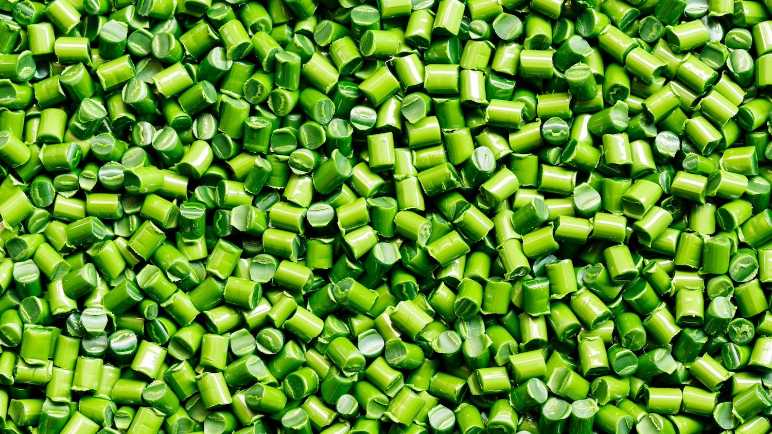 A pile of small, green, recycled plastic pellets — plastic credits