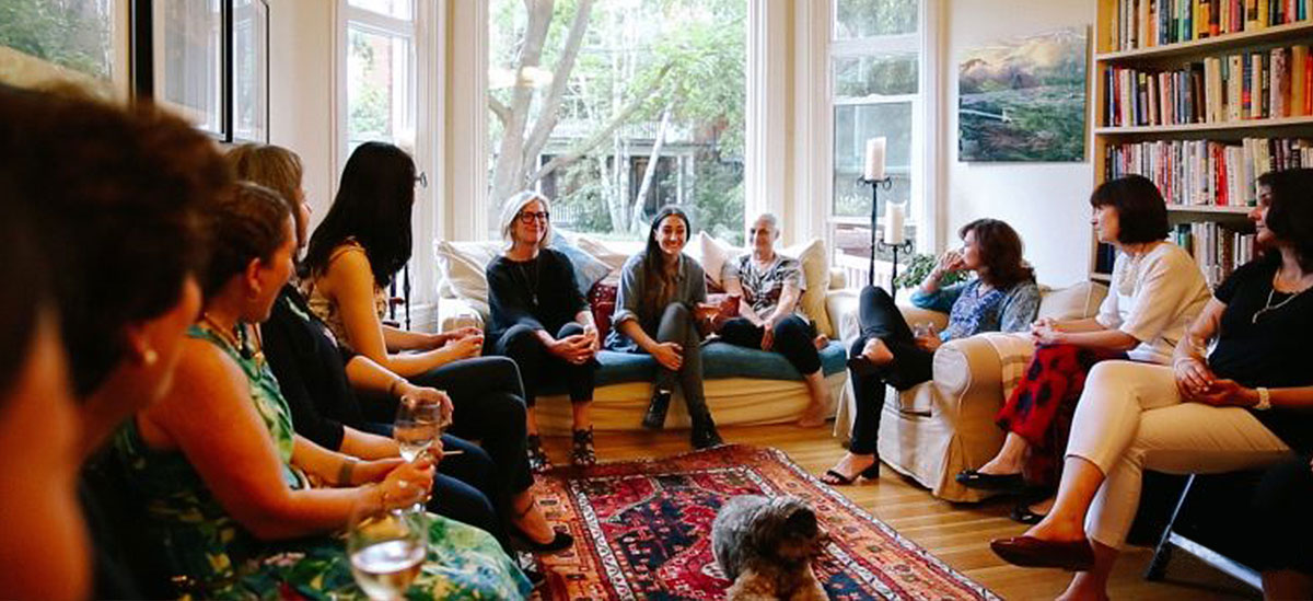 group of women holding a roundtable discussion in a living room environment