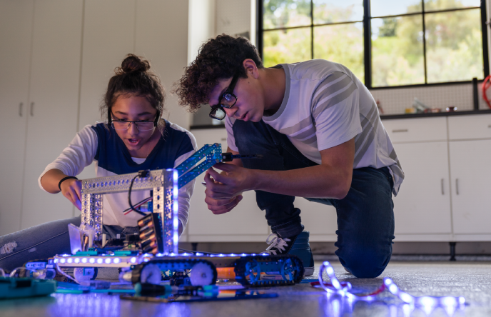 Image of two kids building a robot together