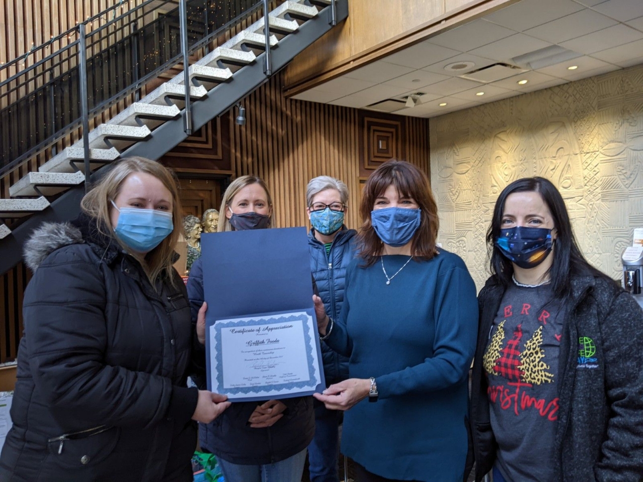 5 Masked people holding an award