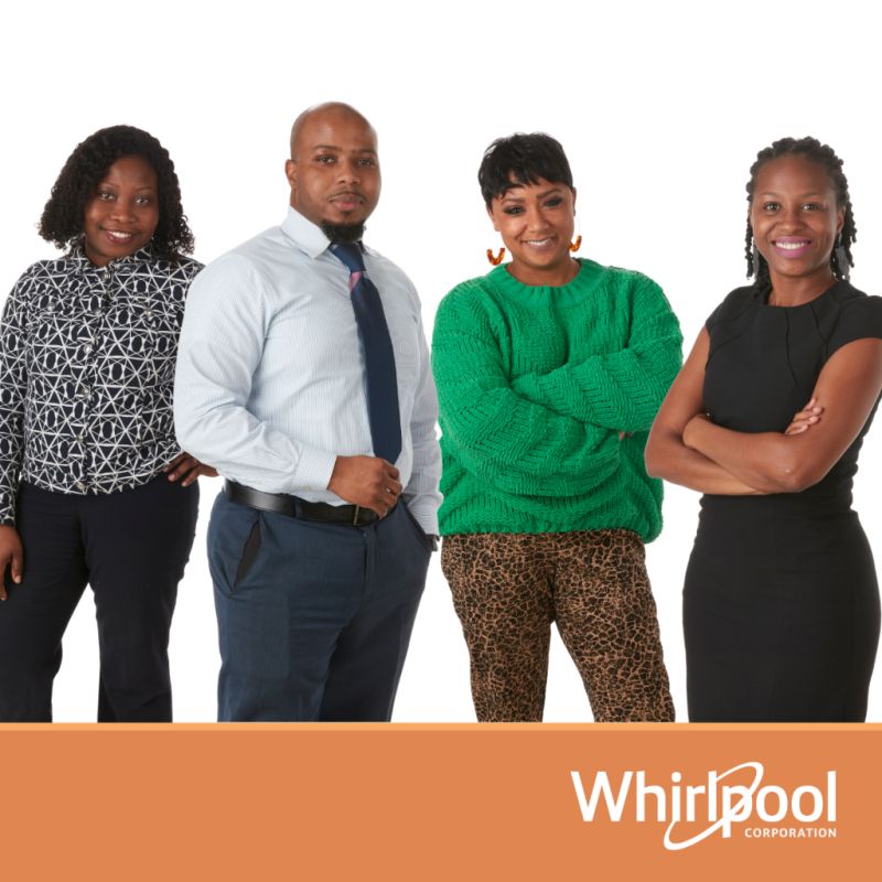 Four people standing in front of a Whirlpool logo