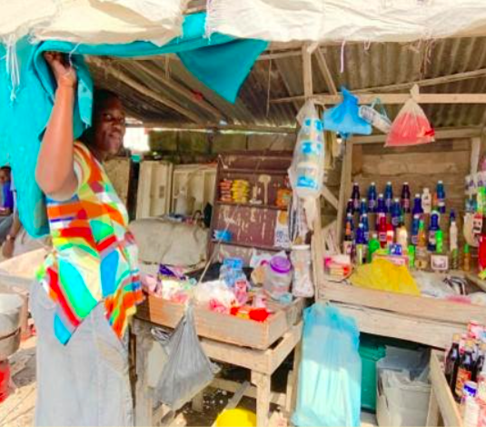 This PMS client shows her roadside kiosk where she sells cooking supplies.