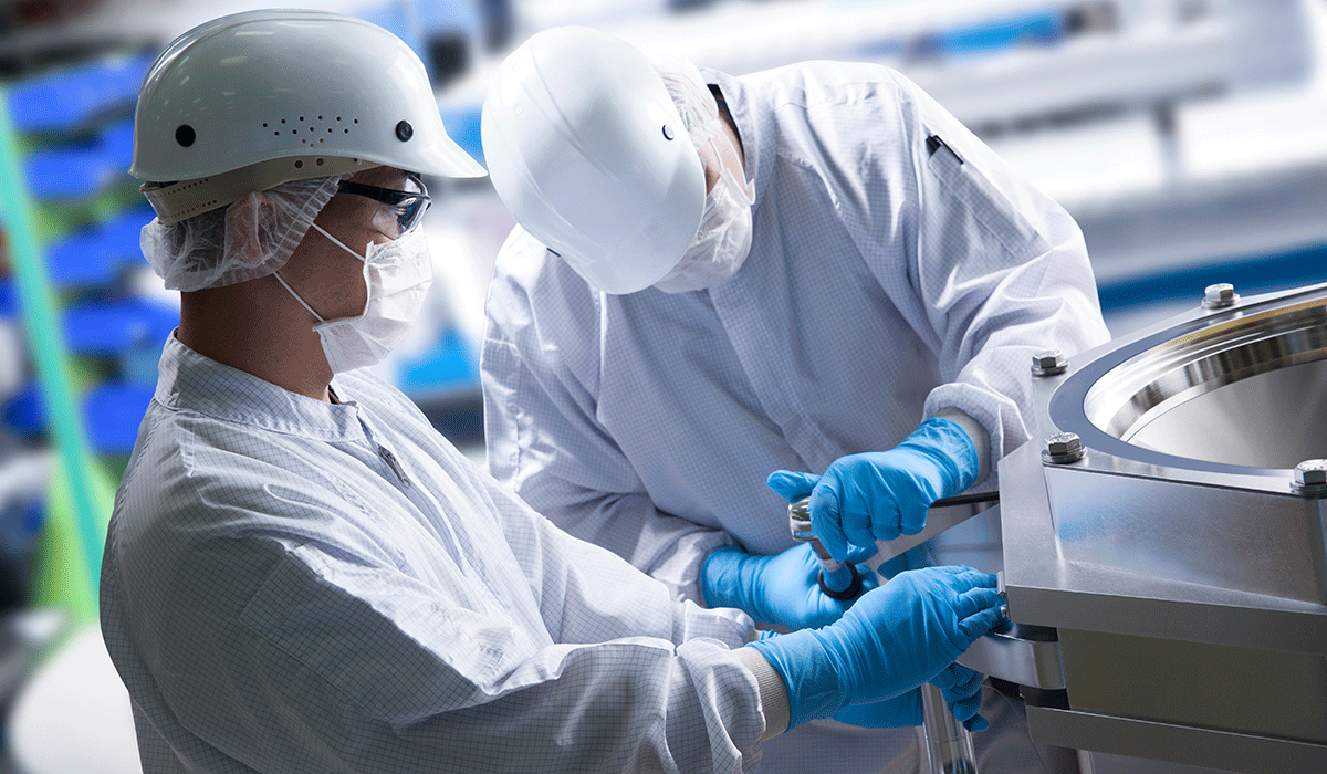 Two workers wearing white protective gear