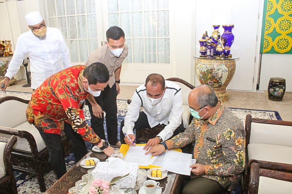 5 people looking down at papers on a table