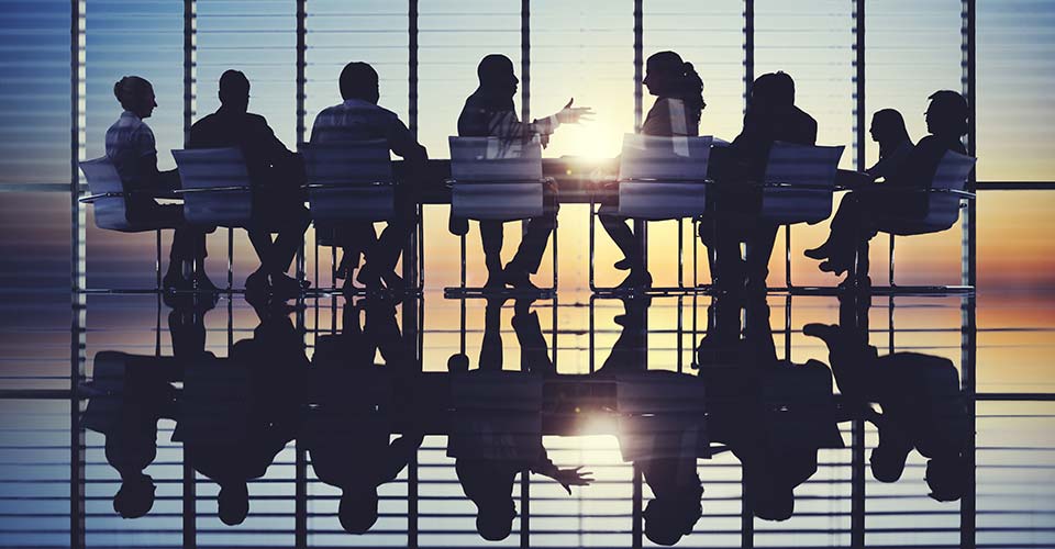 Silhouettes of people meeting at a table