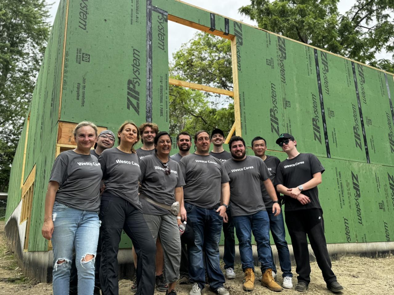 A group smiling in front of building construction