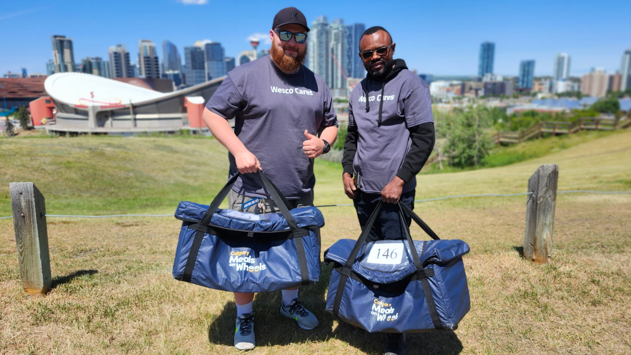 Wesco Cares volunteers smiling and holding blue bags
