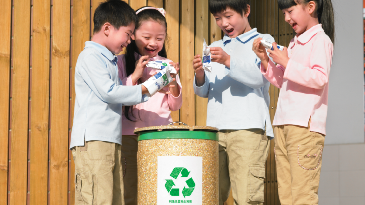 Children around a recylcing container