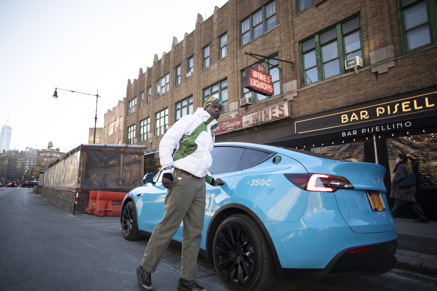 A person opening the door of a Revel rideshare EV. 