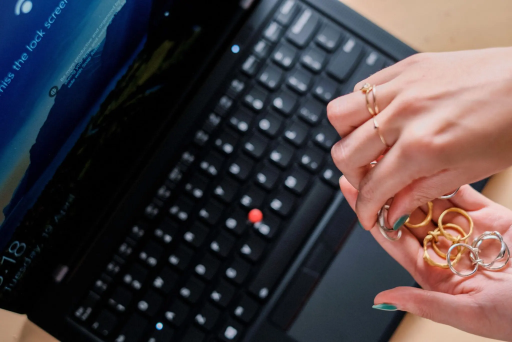 Hands holding rings over a Lenovo laptop
