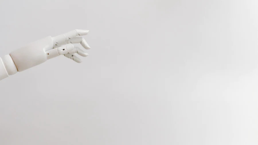 a white robotic hand from the left side of the screen, a white backdrop