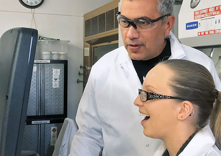 two scientists looking at a monitor