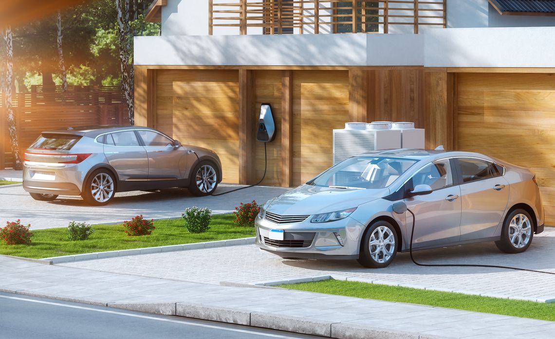 2 electric cars charging in driveways