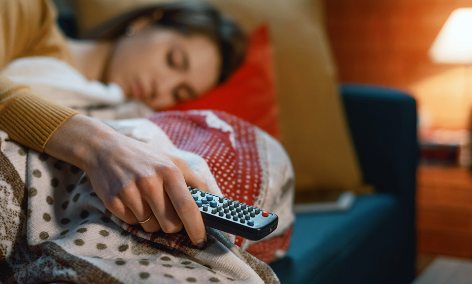 person sleeping with TV remote in hand