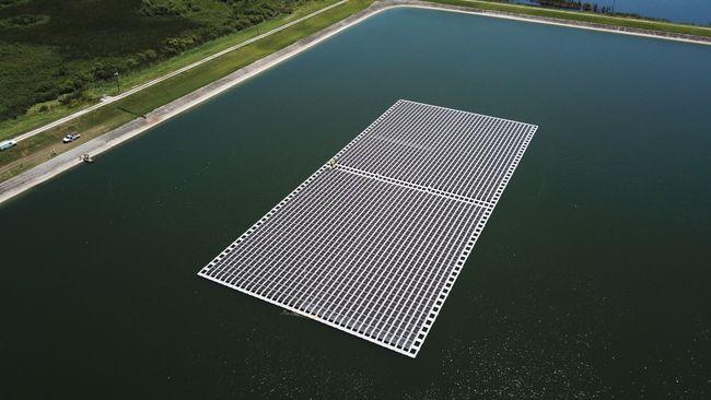 Aerial view of a large floating solar panel grid in a body of water.