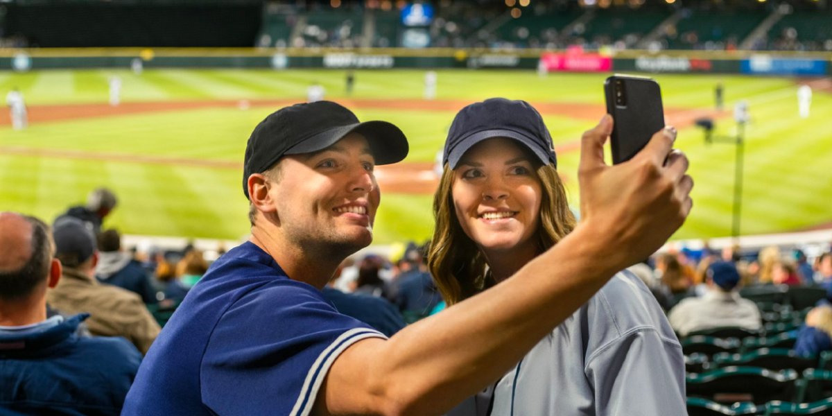 couple taking a selfie at a baseball game