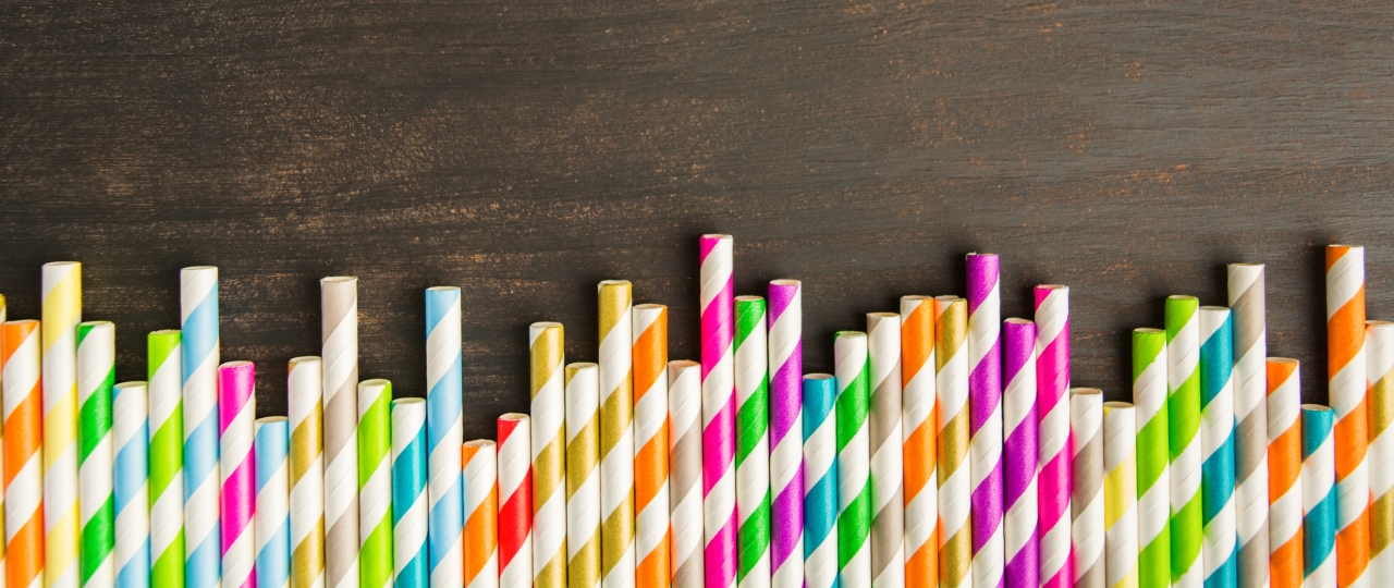 row of striped paper straws on a wood surface