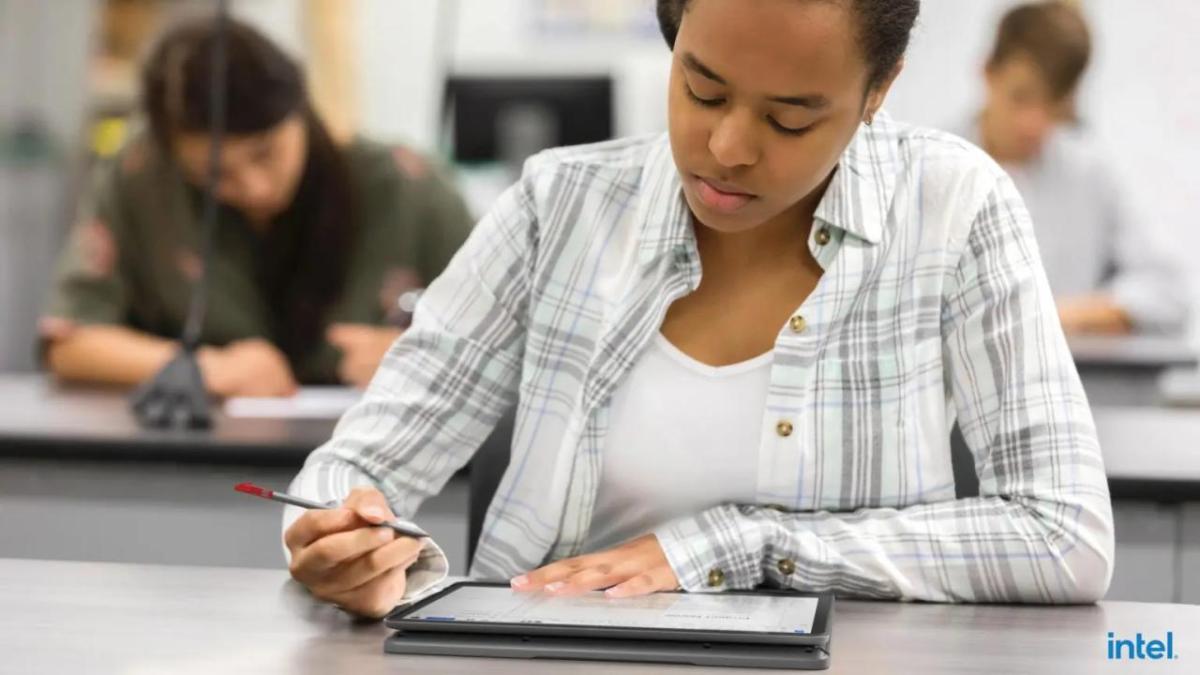 A student looking at a tablet, stylus in one hand.