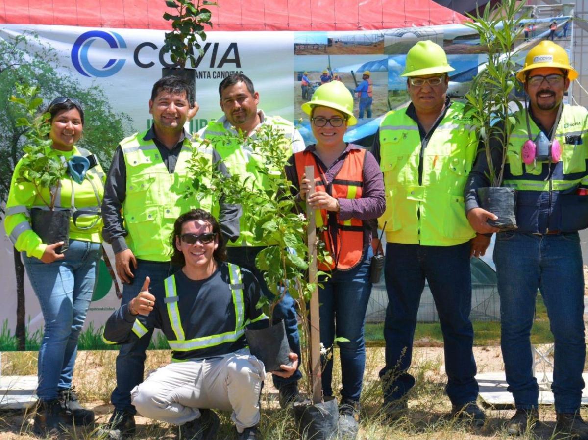 Abel and other teammates holding tree saplings.