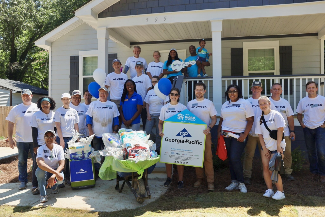 team standing in front of house