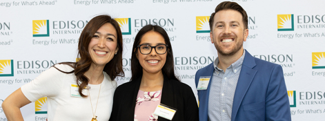 Three people posed in front of an Edison backdrop.
